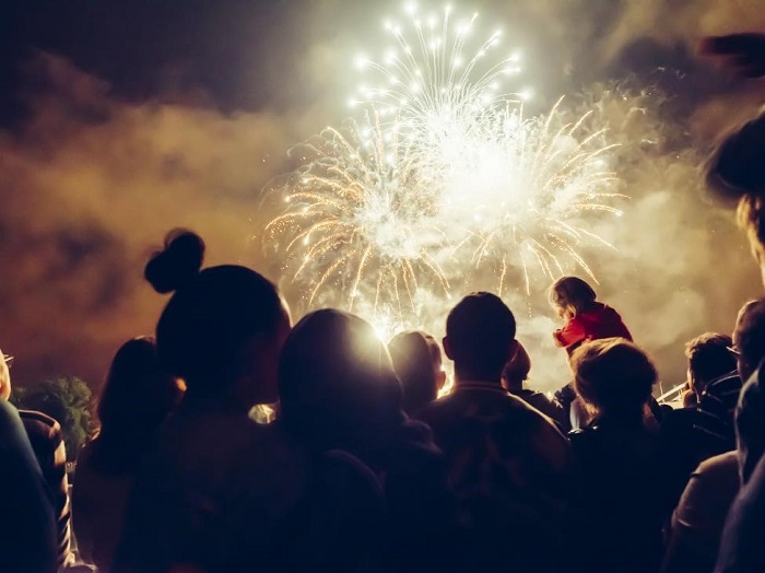 crowd of people watching fireworks show during dusk